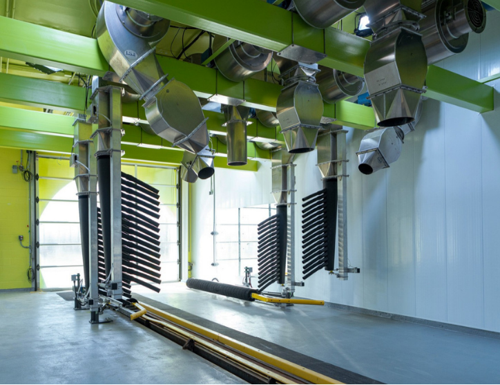 Automated guided vehicle (AGV) system in a warehouse with green walls and white floor.
