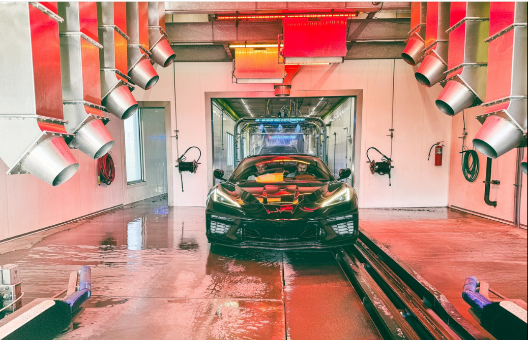 Car on a lift in a garage with red and silver lights