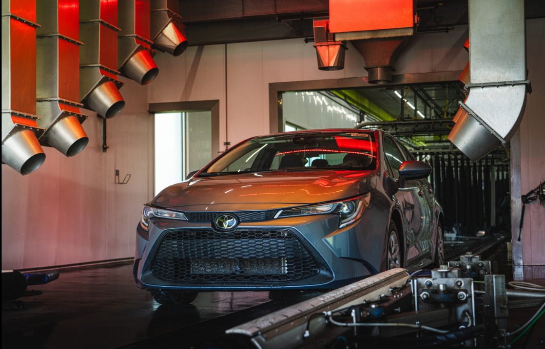 Car on a production line with red and silver lights in a factory setting